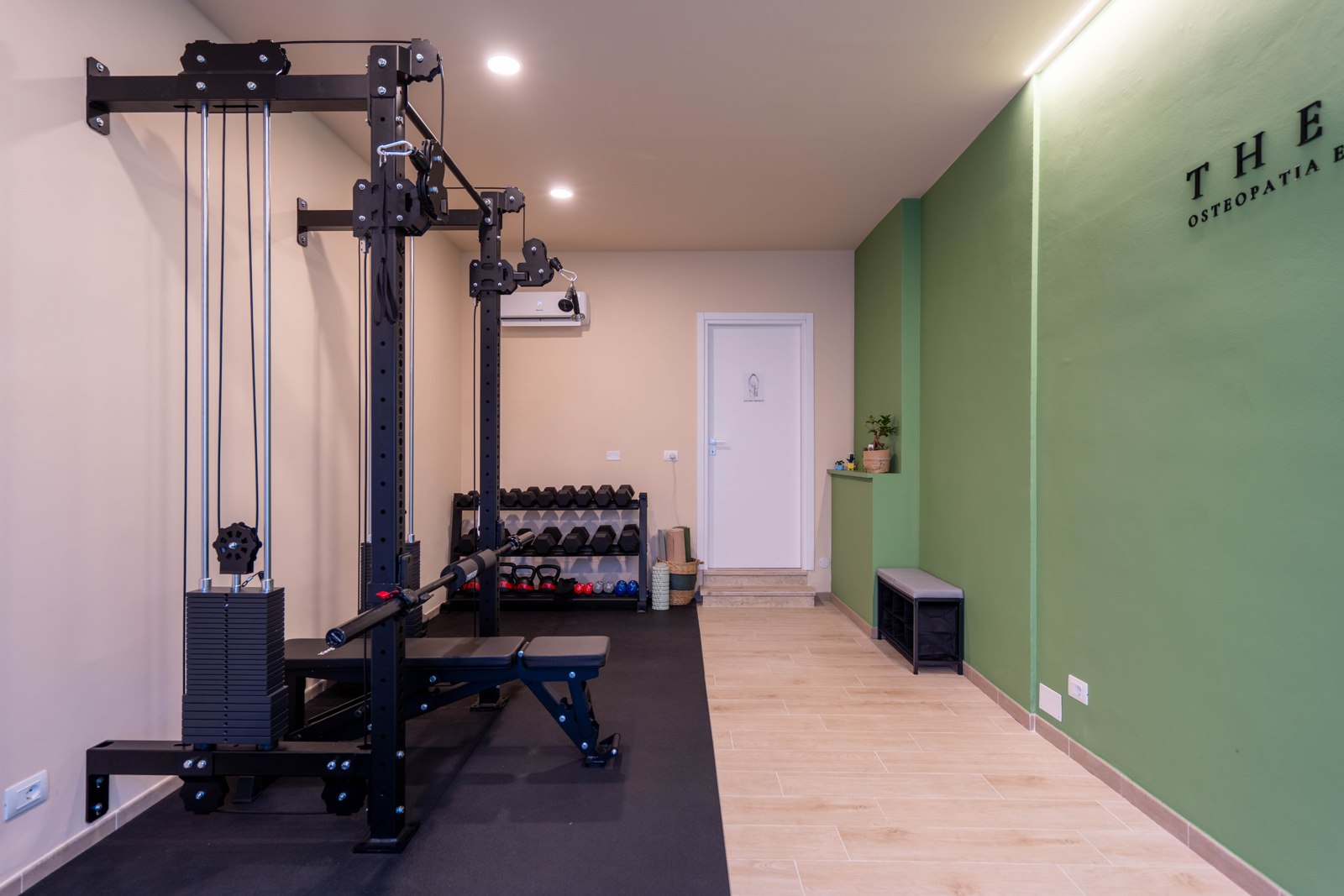 Area training: rack sulla parete crema e parete verde di fronte